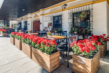 a building with tables and chairs and red flowers