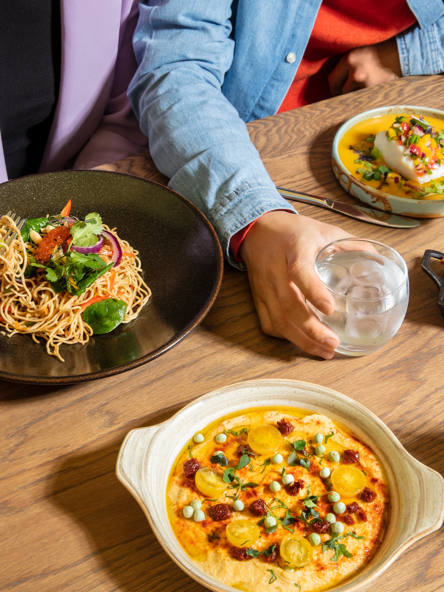 a person sitting at a table with plates of food