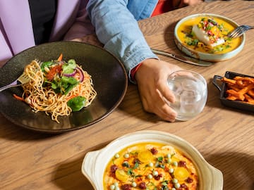 a person sitting at a table with plates of food