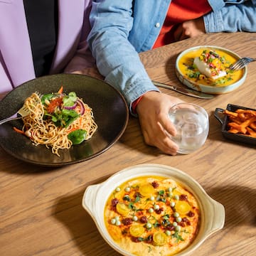 a person sitting at a table with plates of food