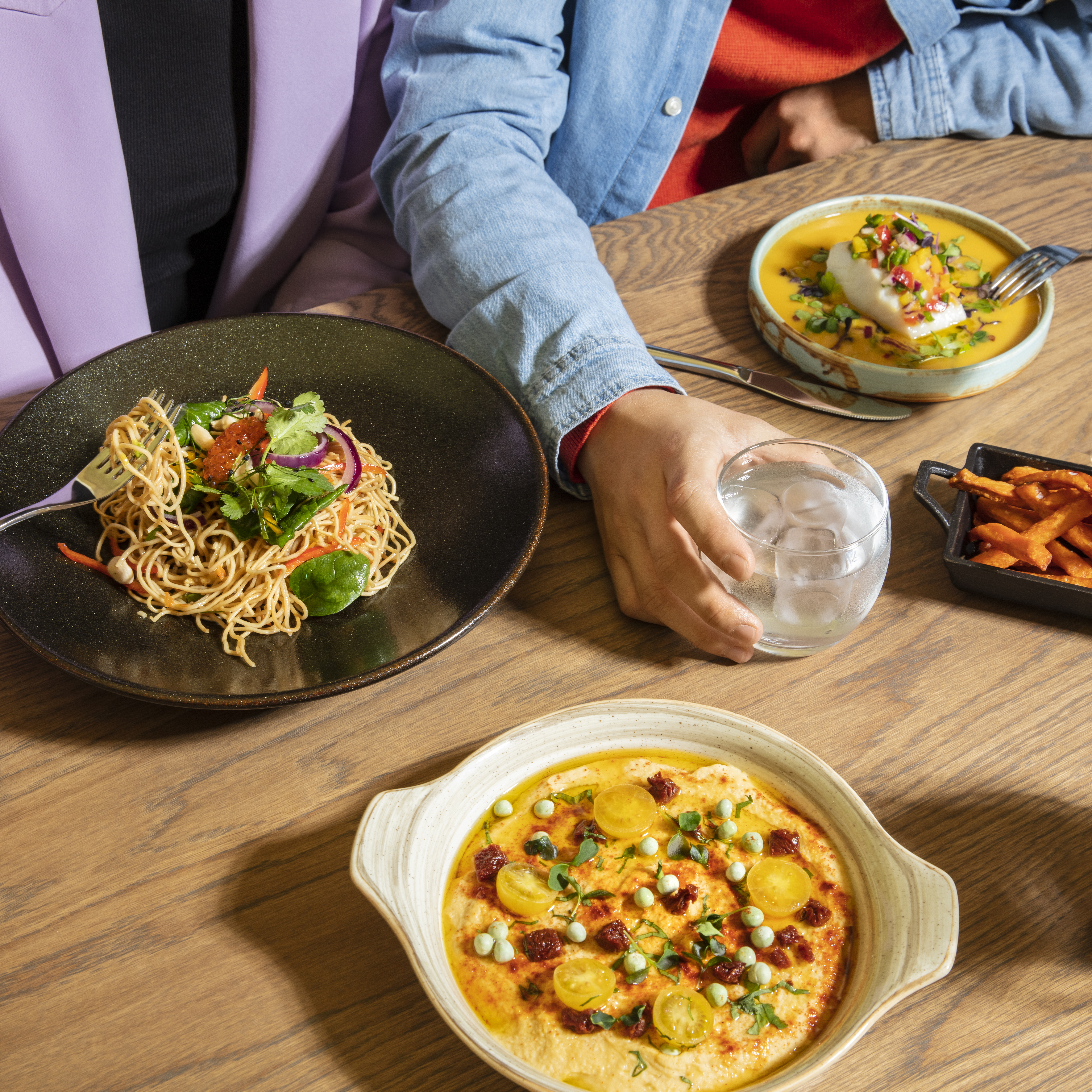 a person sitting at a table with plates of food