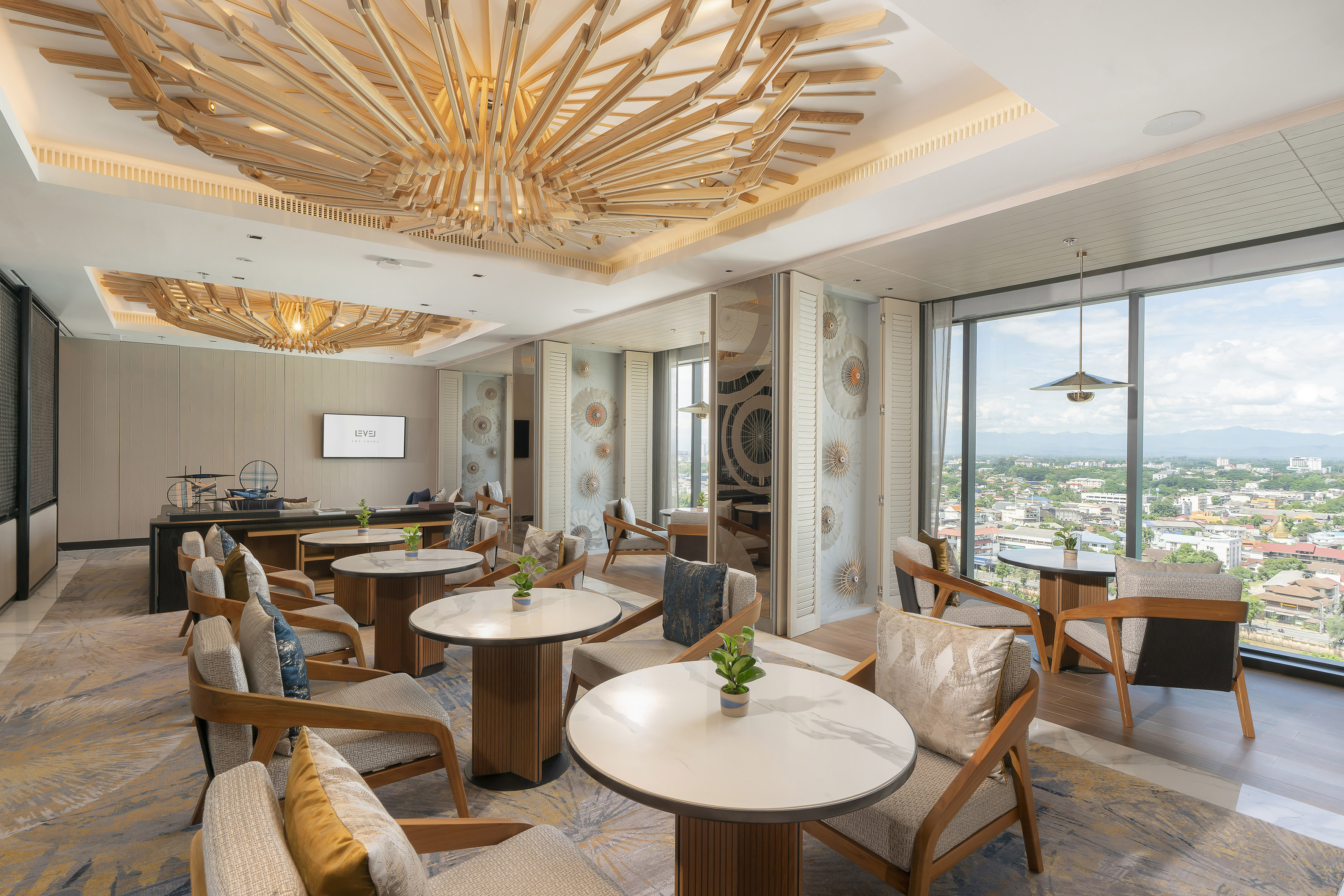 Executive lounge with city view, ornate wooden ceiling, and modern seating.