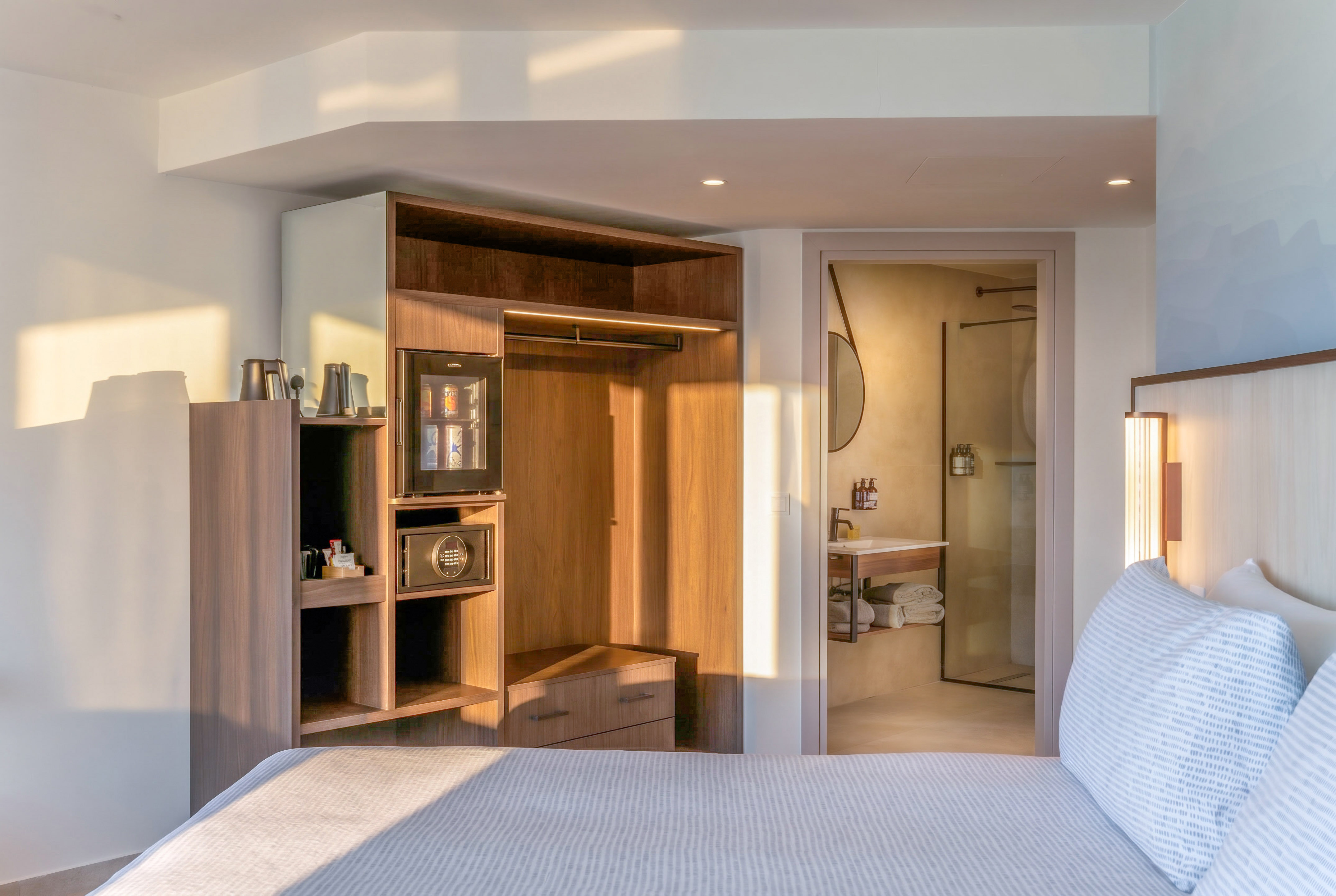 Modern hotel bedroom with bed, integrated closet, mini-bar, and bathroom. - The INNSiDE Room بإطلالة على البحر مع شرفة - INNSiDE Bugibba, بوجيبا