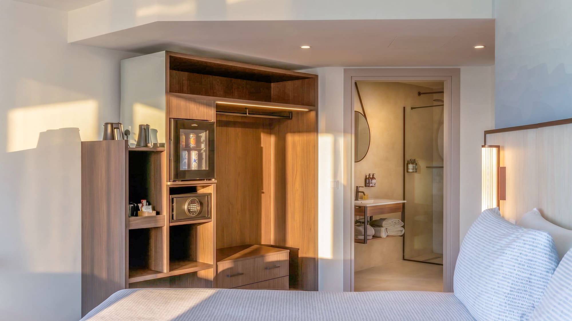Modern hotel bedroom with bed, integrated closet, mini-bar, and bathroom. - The INNSiDE Room シービュー（テラス付き） - INNSiDE Bugibba, ブジッバ