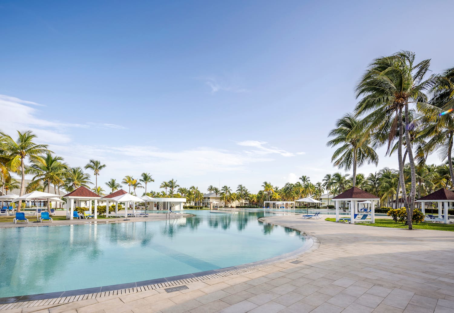 a pool with gazebos and palm trees