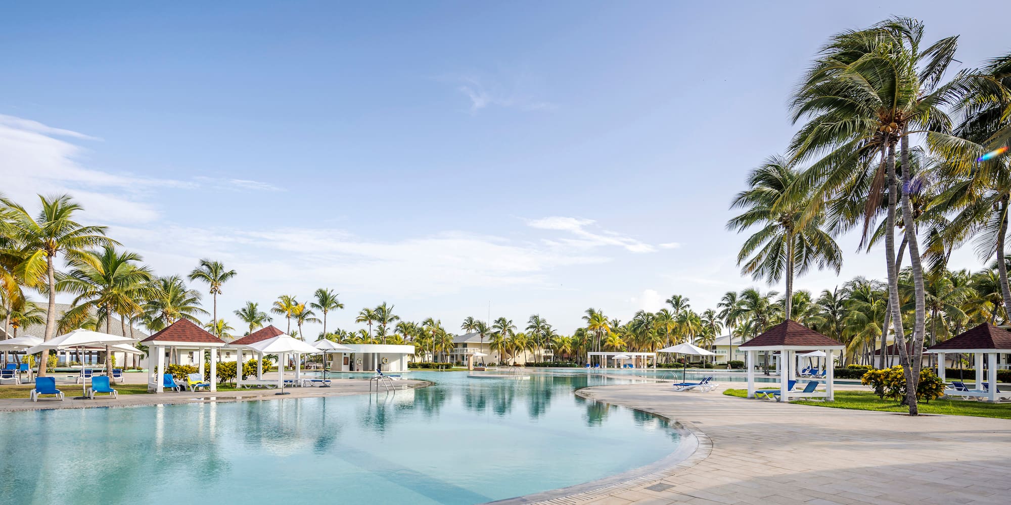 a pool with gazebos and palm trees
