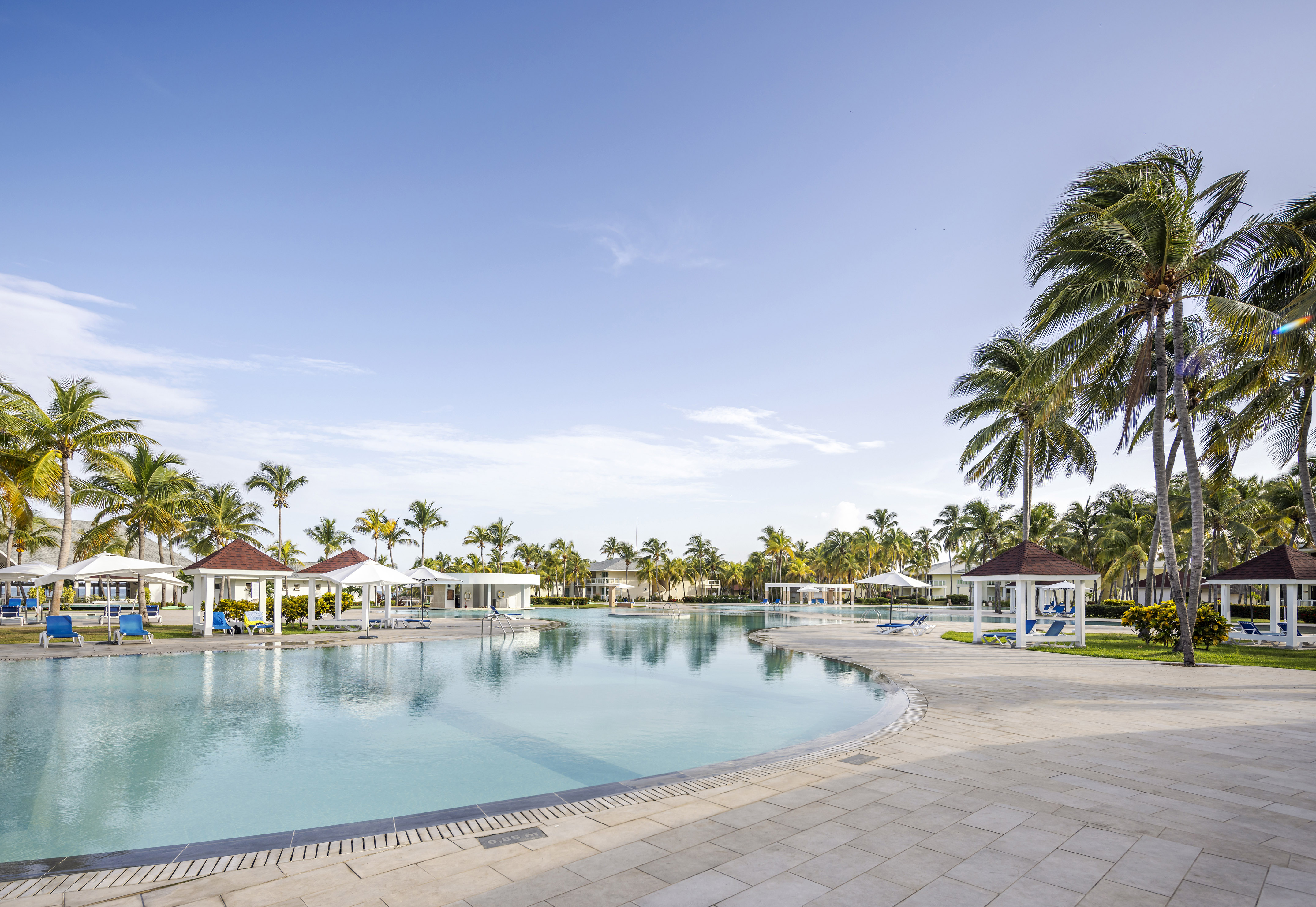 a pool with gazebos and palm trees