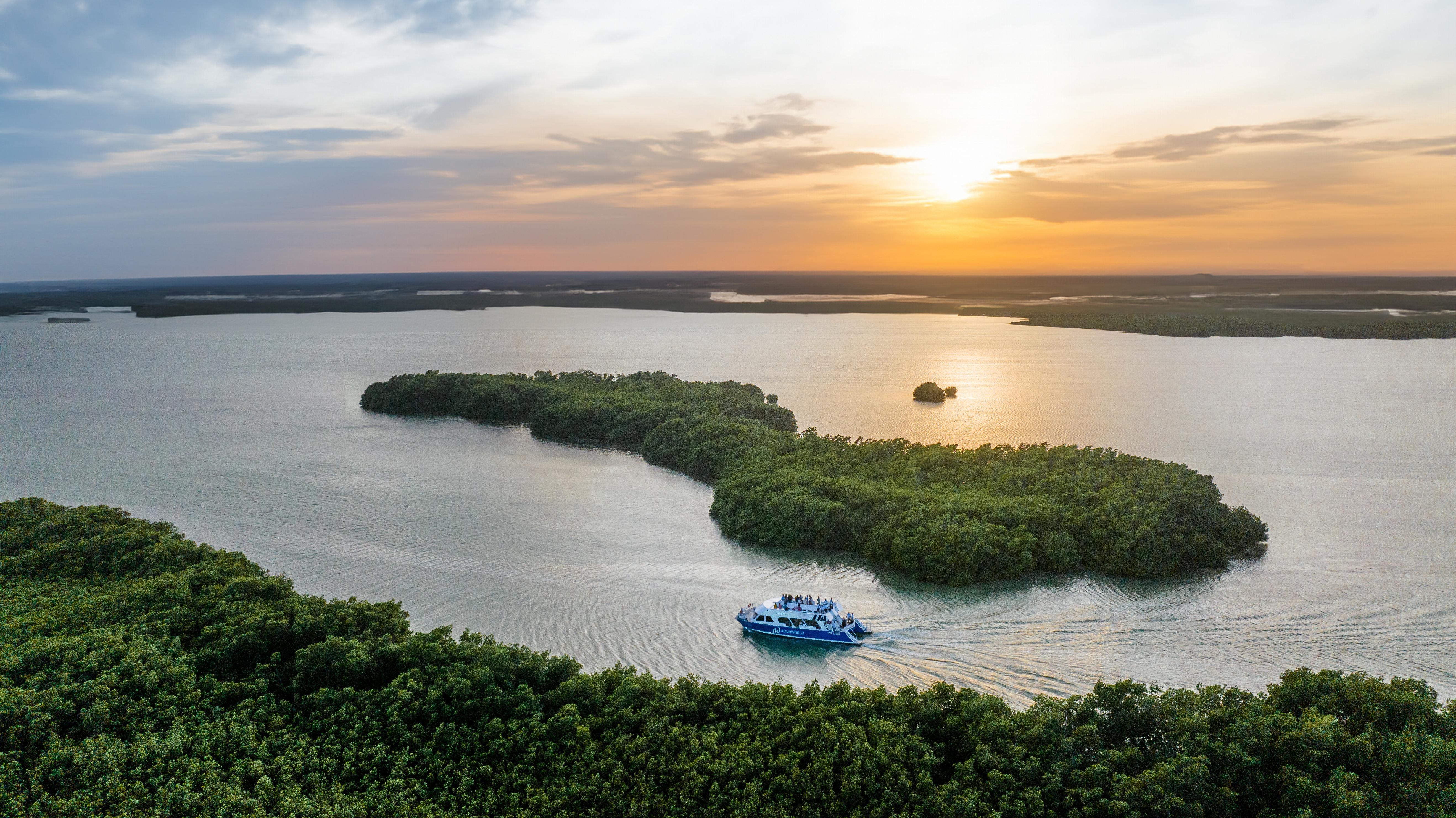 Aerial sunset boat tour near mangrove islands.