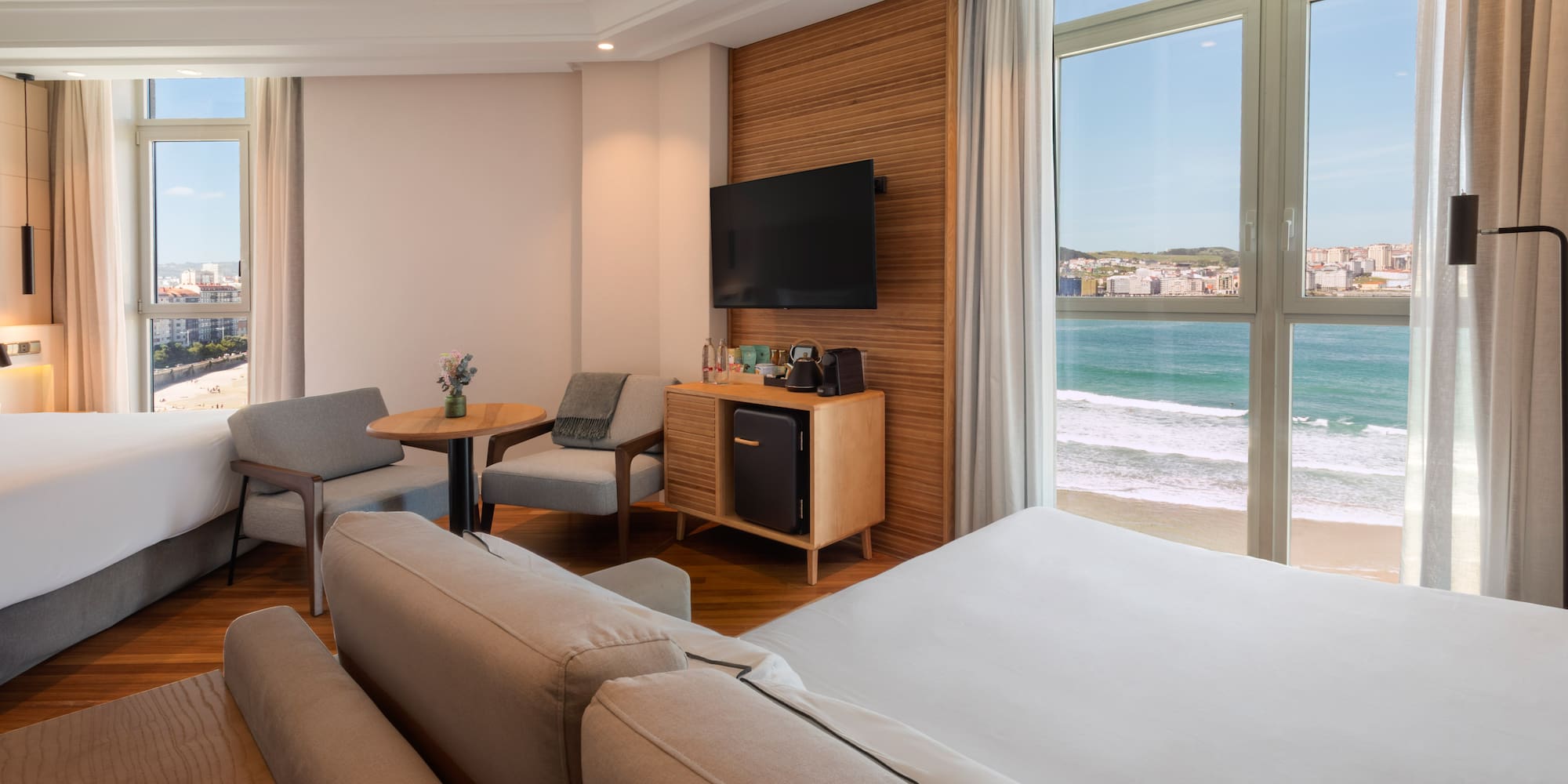 a room with a large bed and a television and chairs