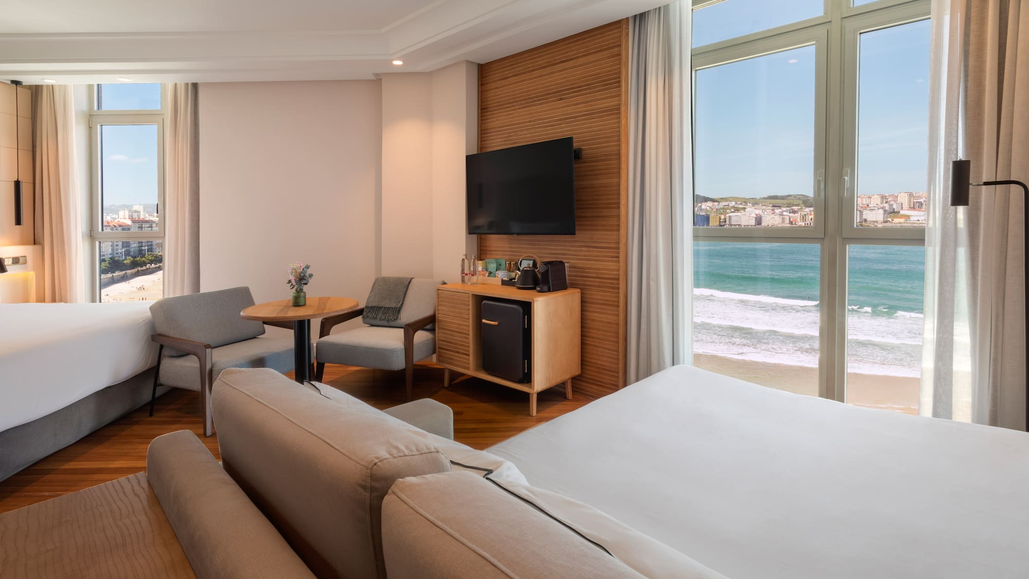 a room with a large bed and a television and chairs