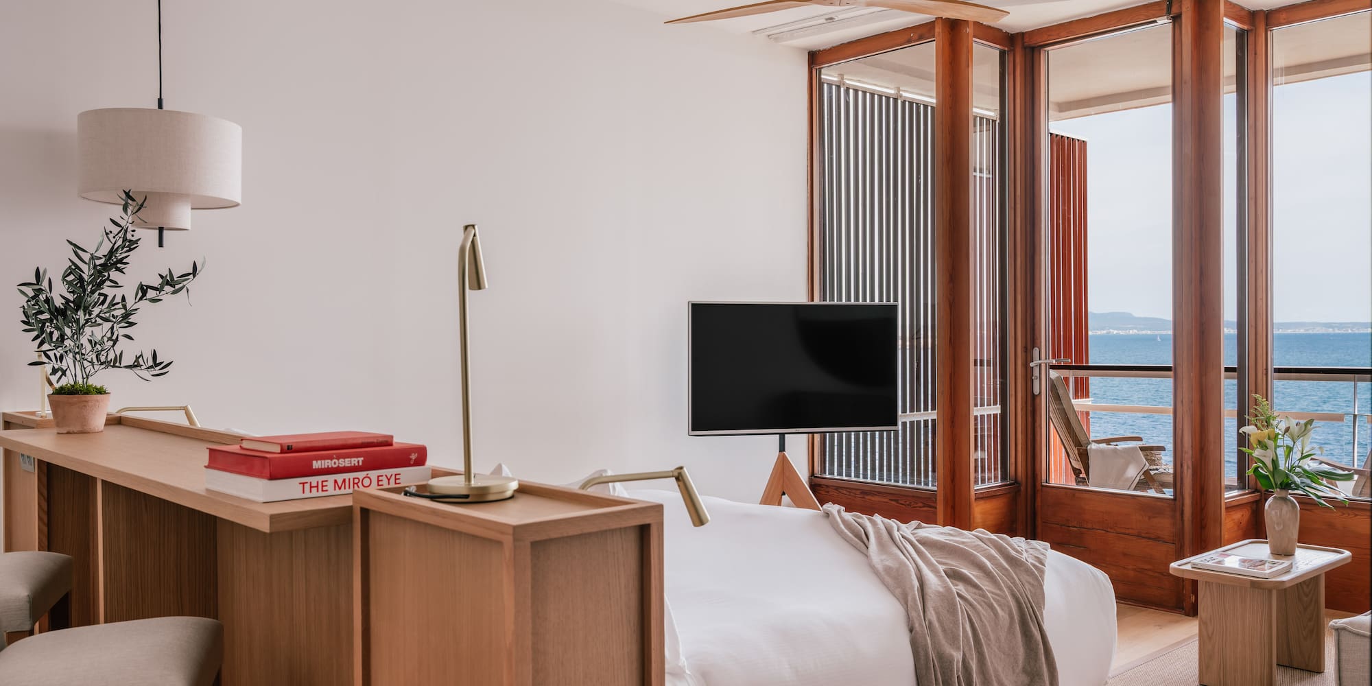 a room with a bed and a table and a window