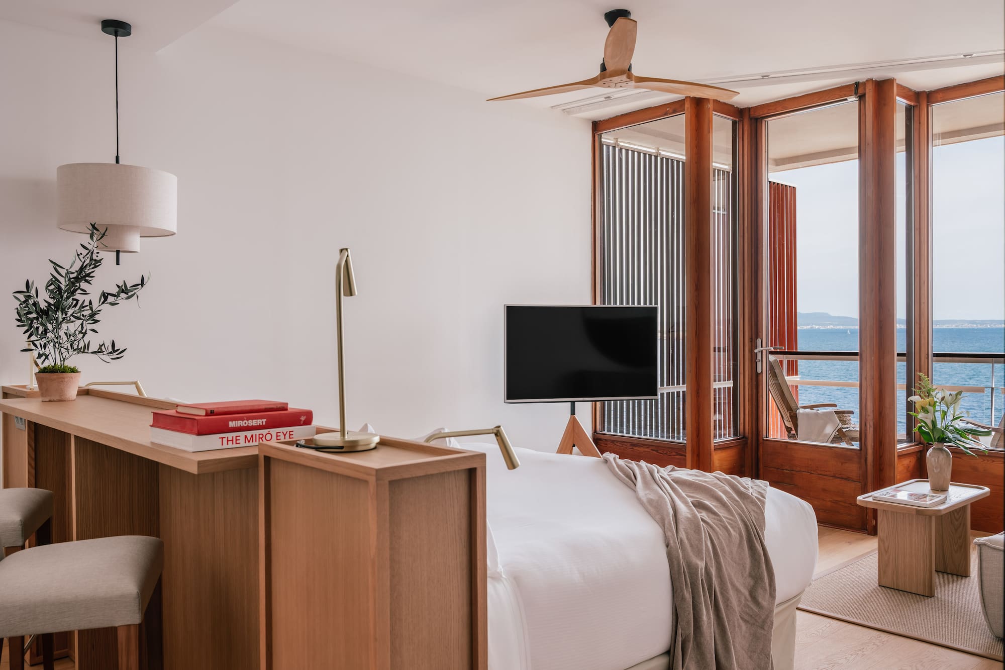 a room with a bed and a table and a window