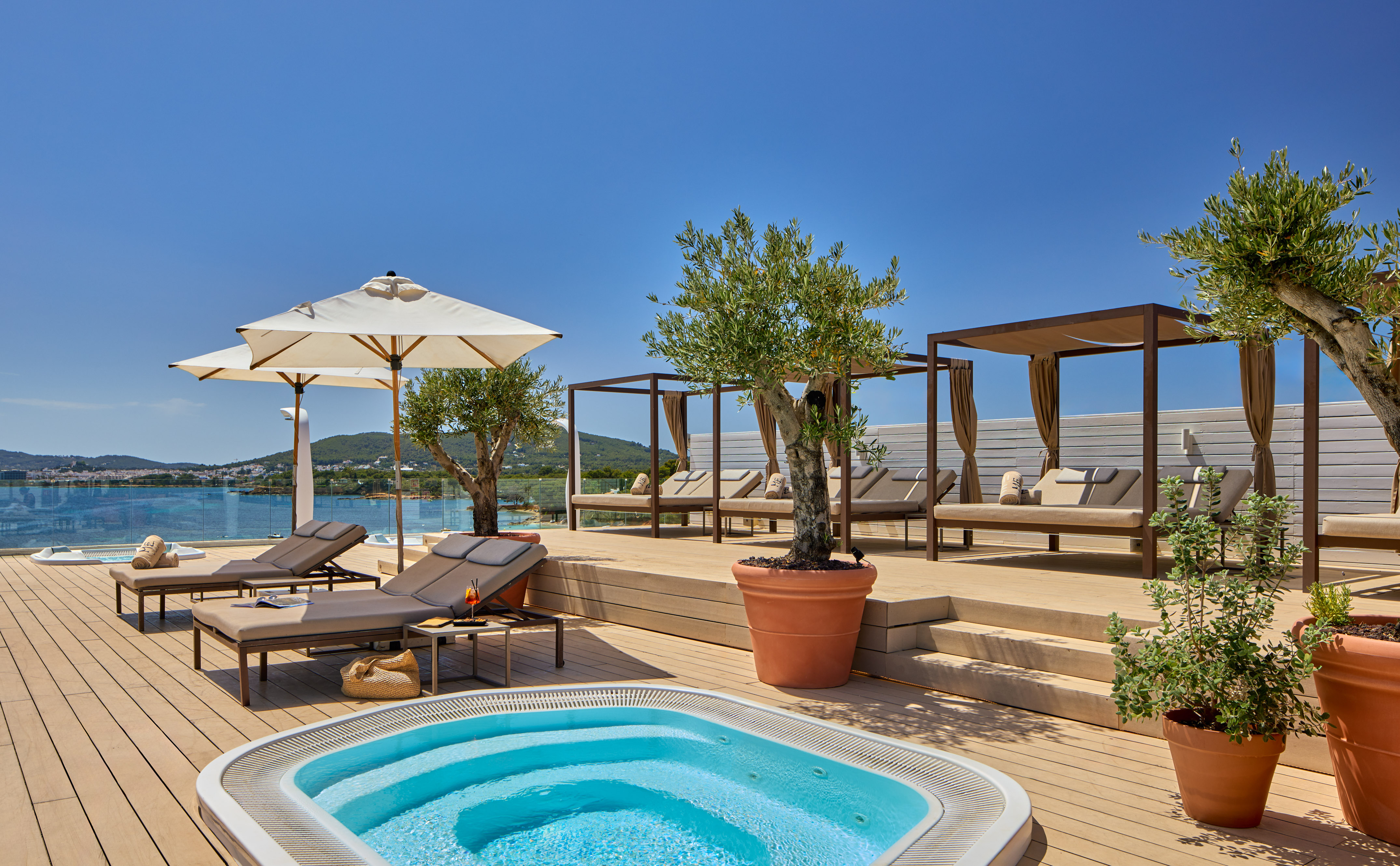 Rooftop terrace, hot tub, sunbeds, cabanas, olive trees, ocean view.