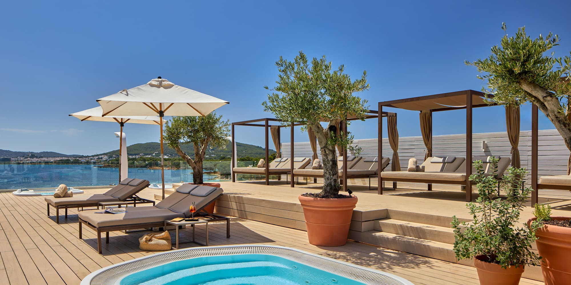 Rooftop terrace, hot tub, sunbeds, cabanas, olive trees, ocean view.
