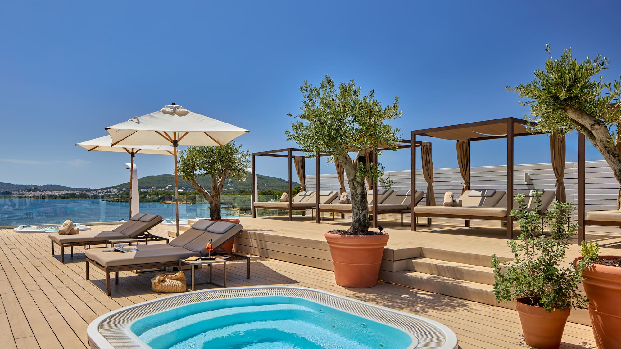 Rooftop terrace, hot tub, sunbeds, cabanas, olive trees, ocean view.