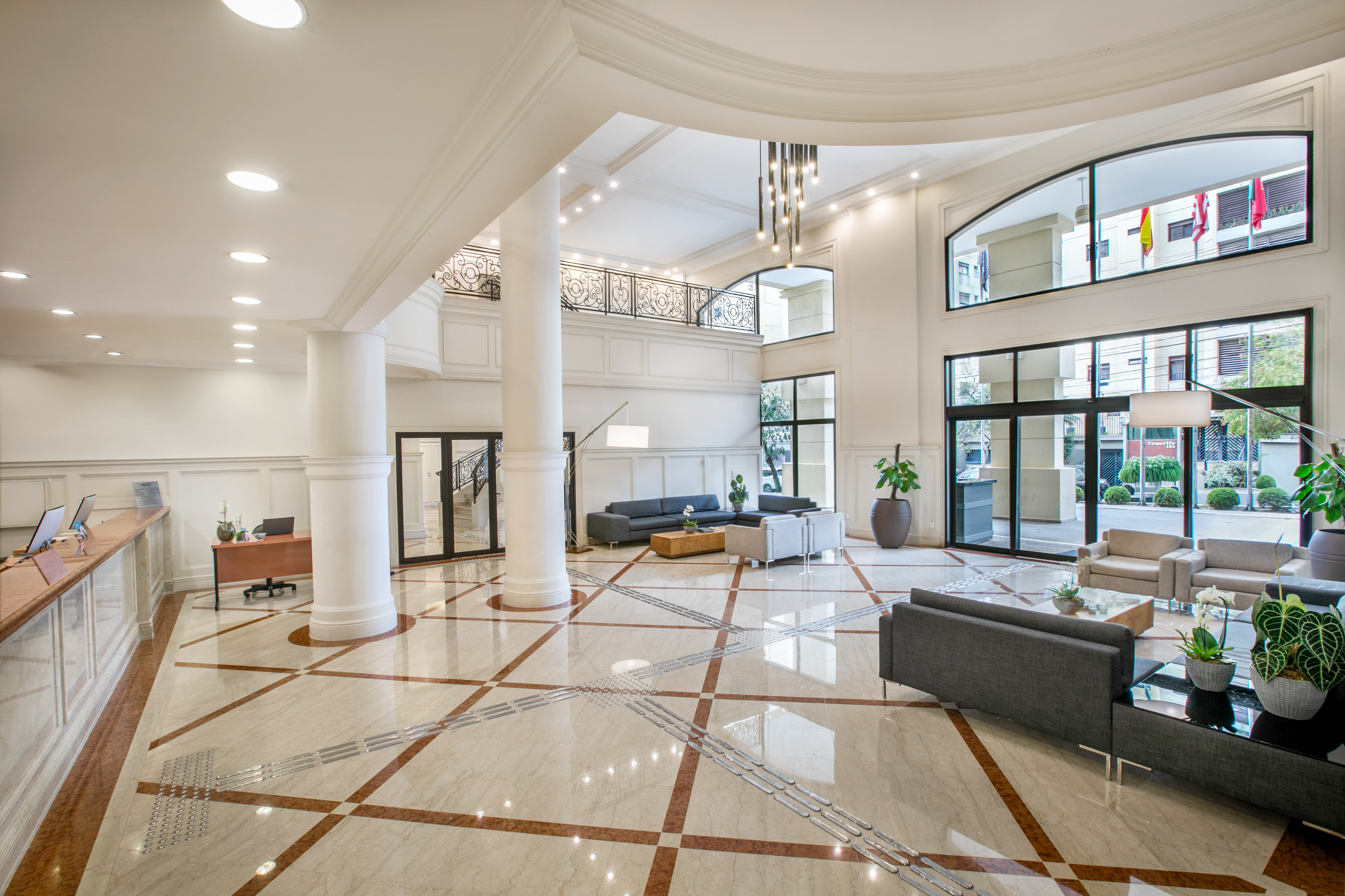 Spacious, elegant hotel lobby with high ceilings, marble floor, and modern seating.