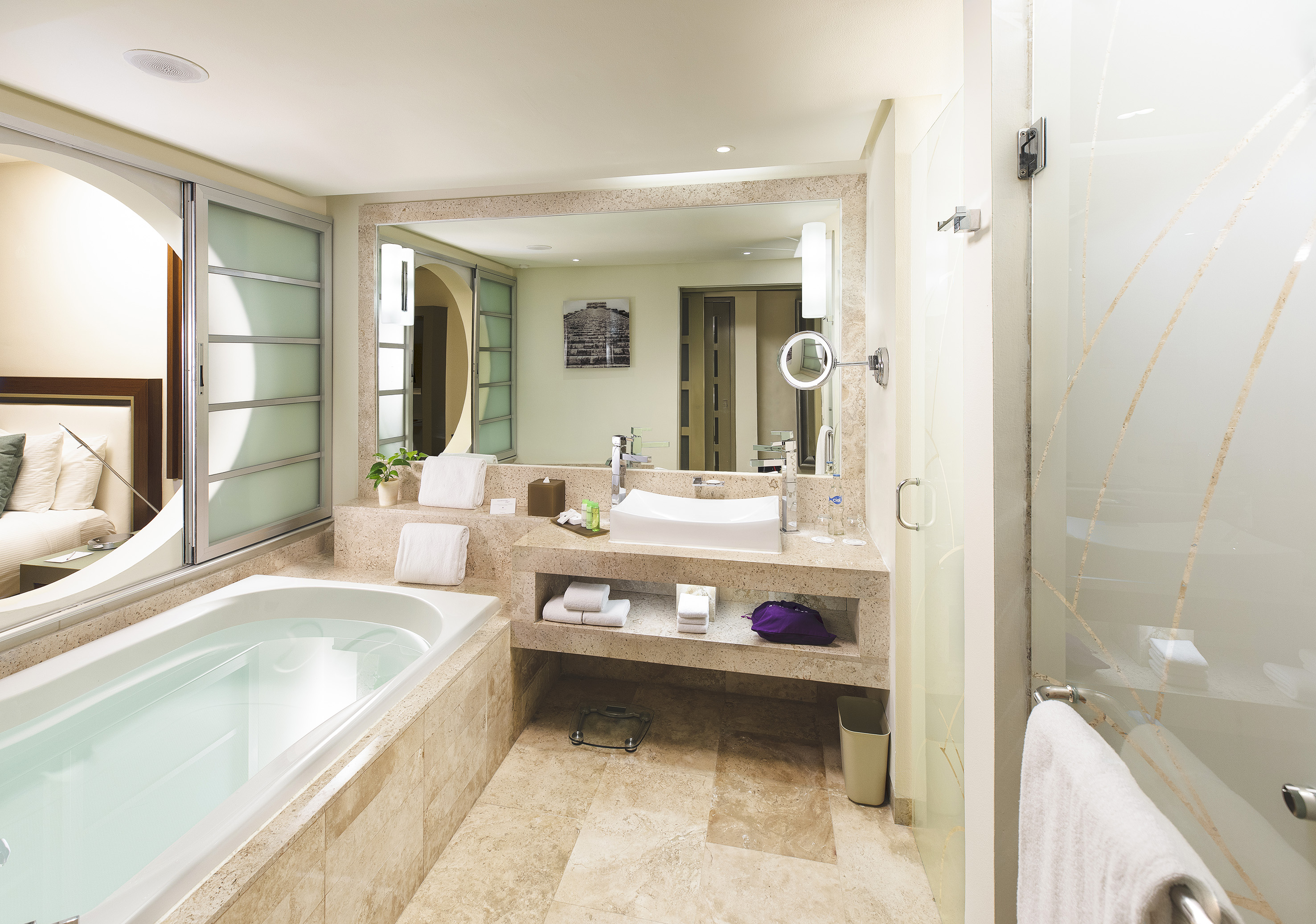 Modern luxury hotel bathroom with large bathtub, vanity, and glass shower.