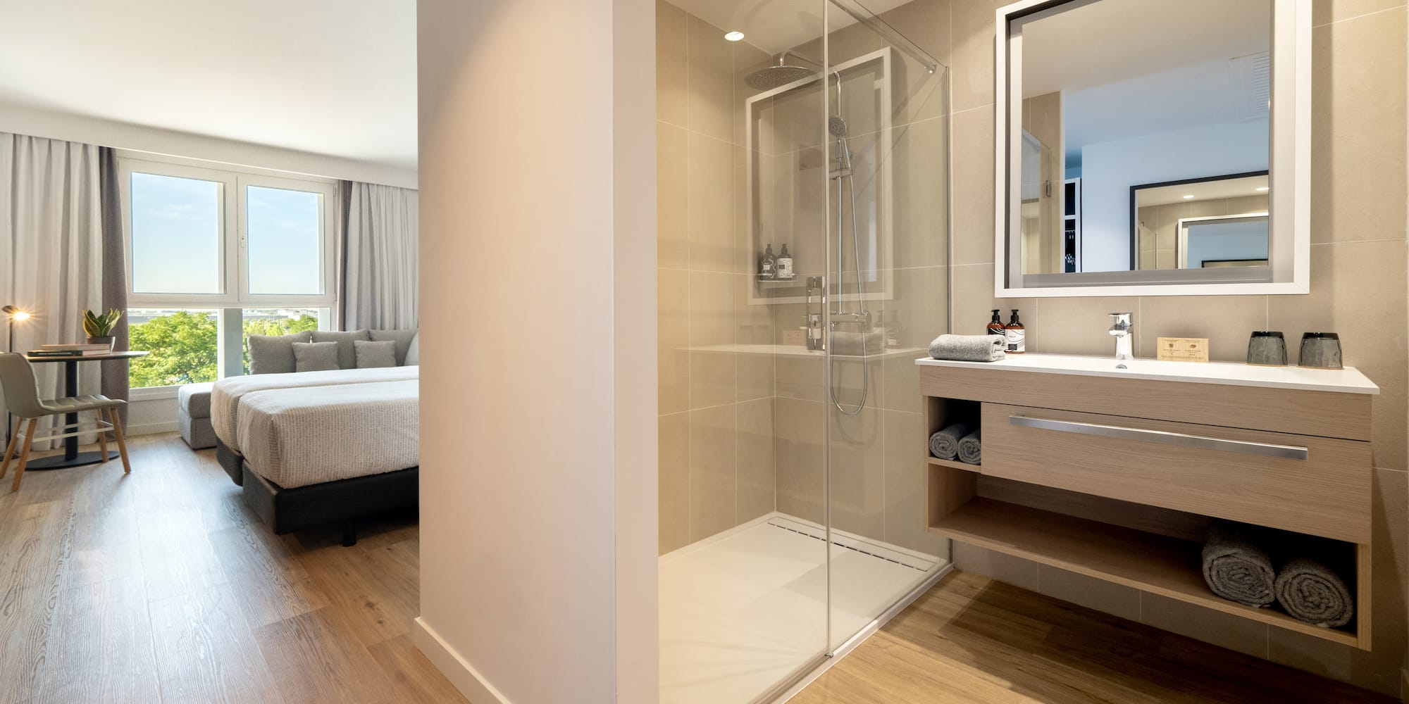 a bathroom with a glass shower and a bed