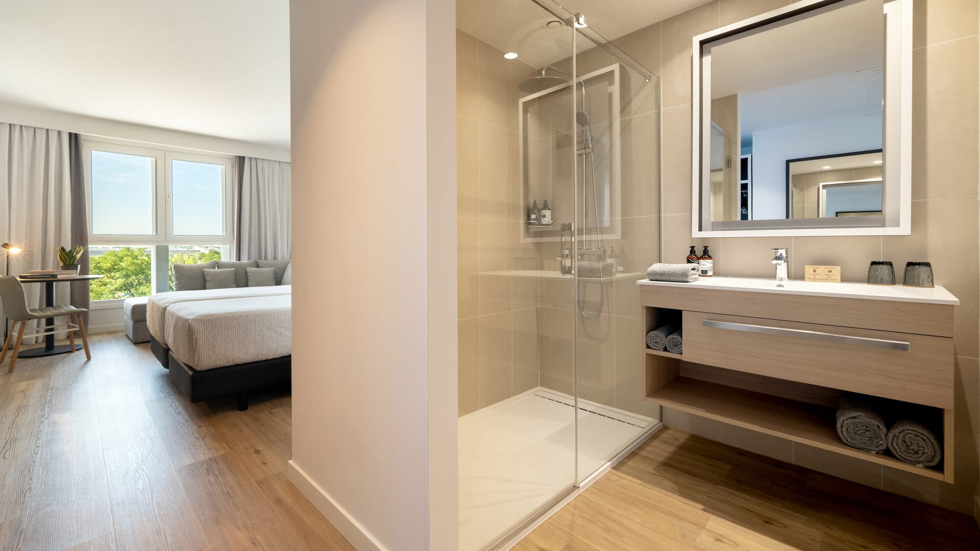 a bathroom with a glass shower and a bed