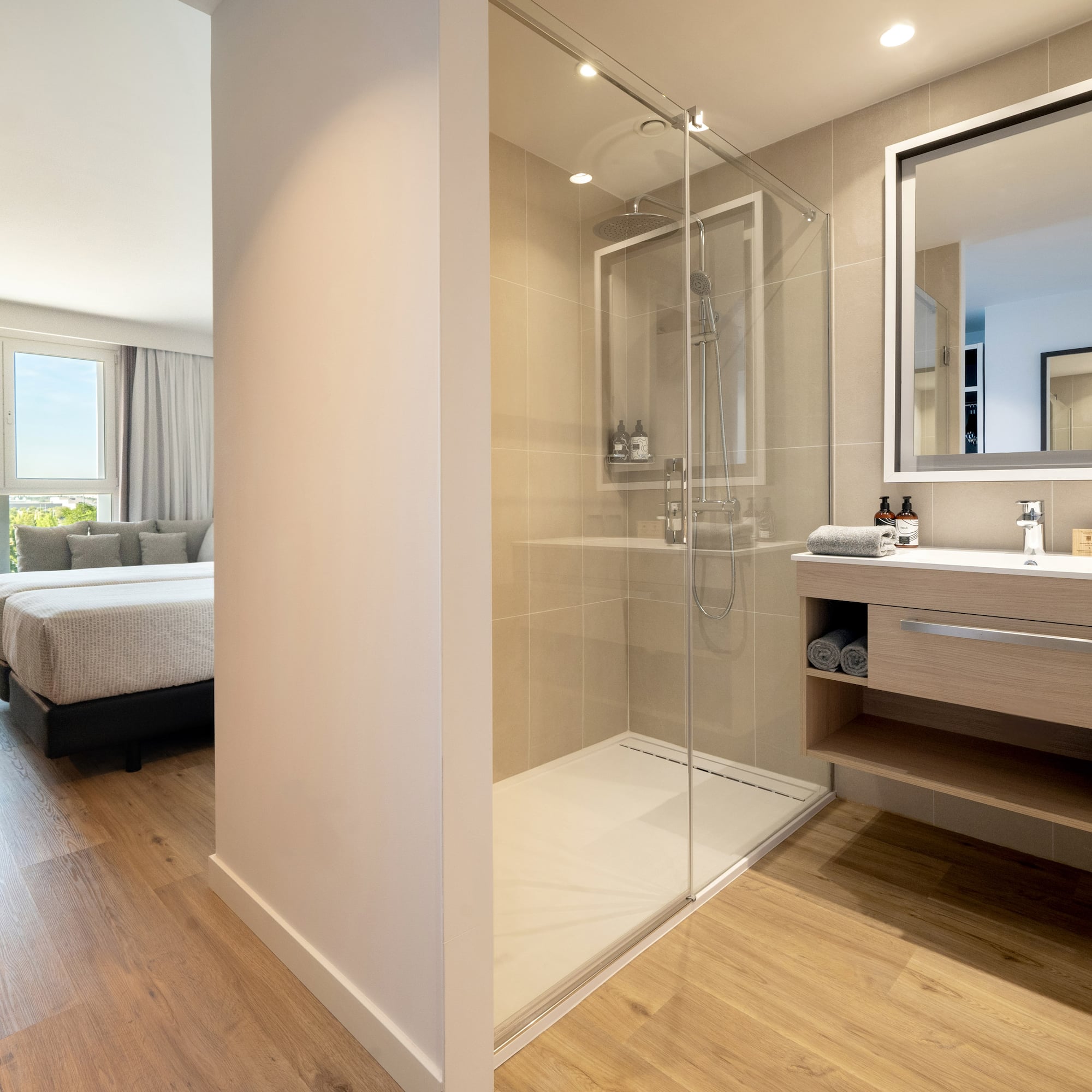 a bathroom with a glass shower and a bed