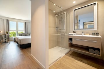 a bathroom with a glass shower and a bed