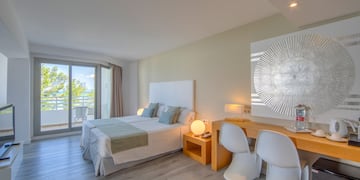 a room with a bed and a desk and chairs