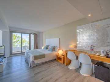 a room with a bed and a desk and chairs