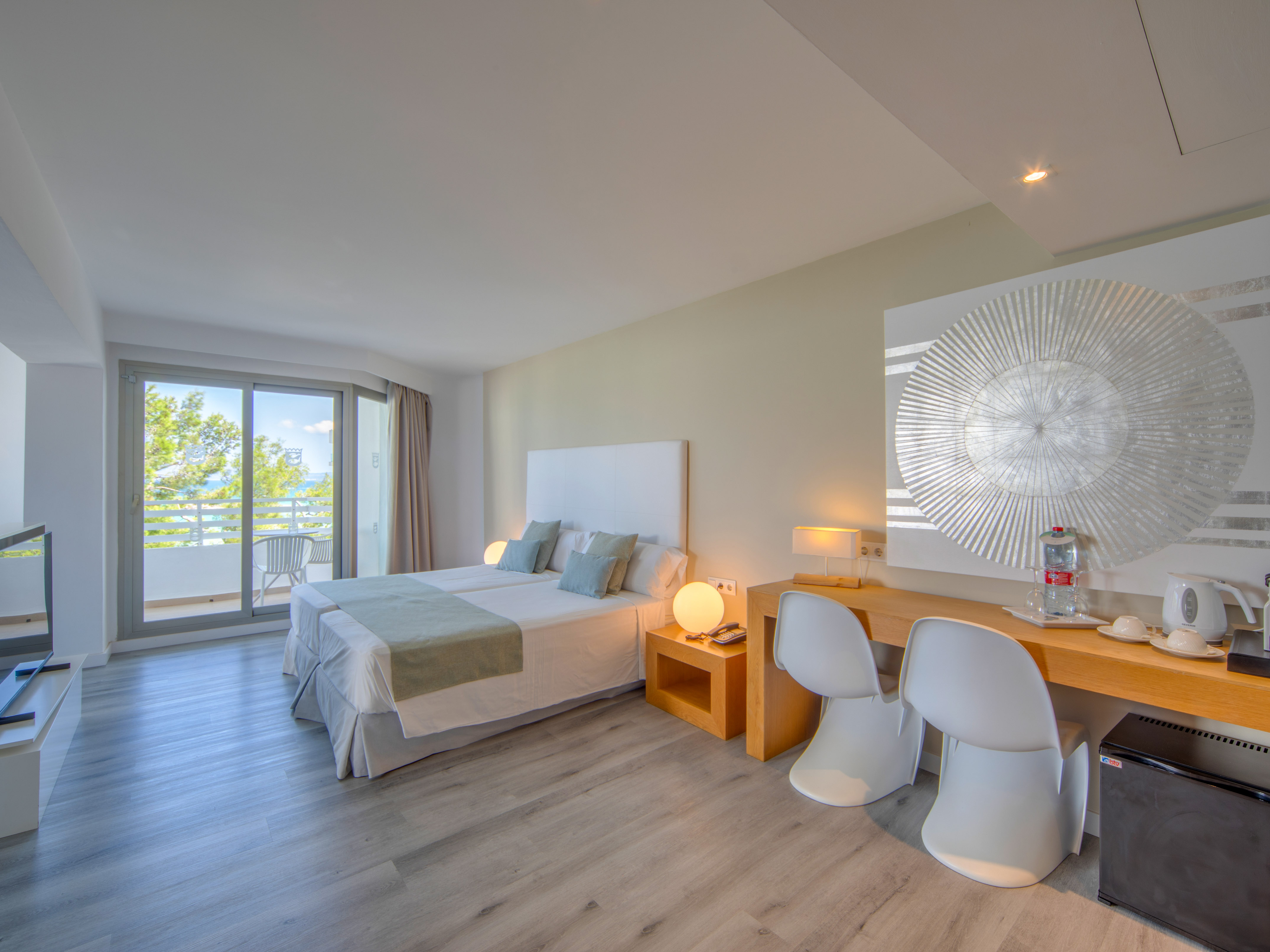 a room with a bed and a desk and chairs