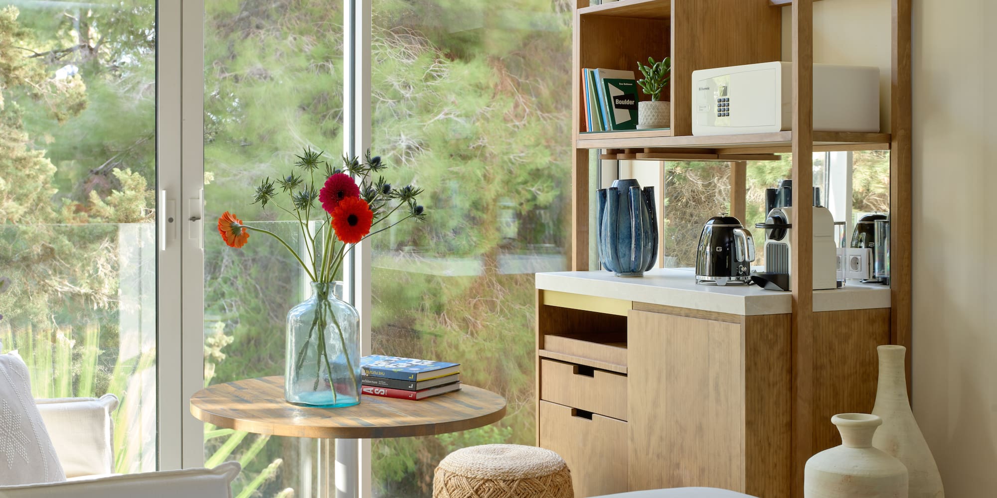 a room with a table and a coffee maker and a window