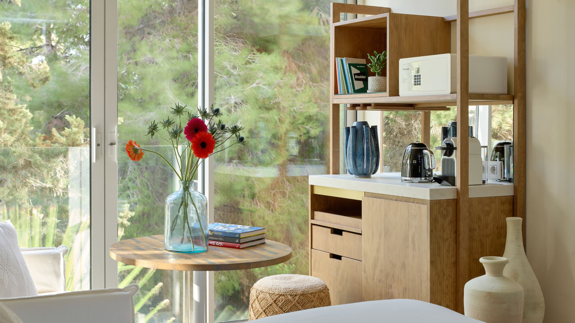 a room with a table and a coffee maker and a window