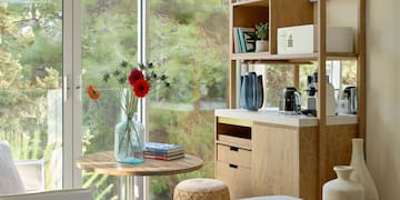 a room with a table and a coffee maker and a window