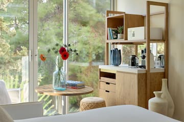 a room with a table and a coffee maker and a window