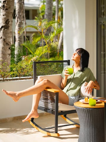 a woman sitting on a chair holding a drink