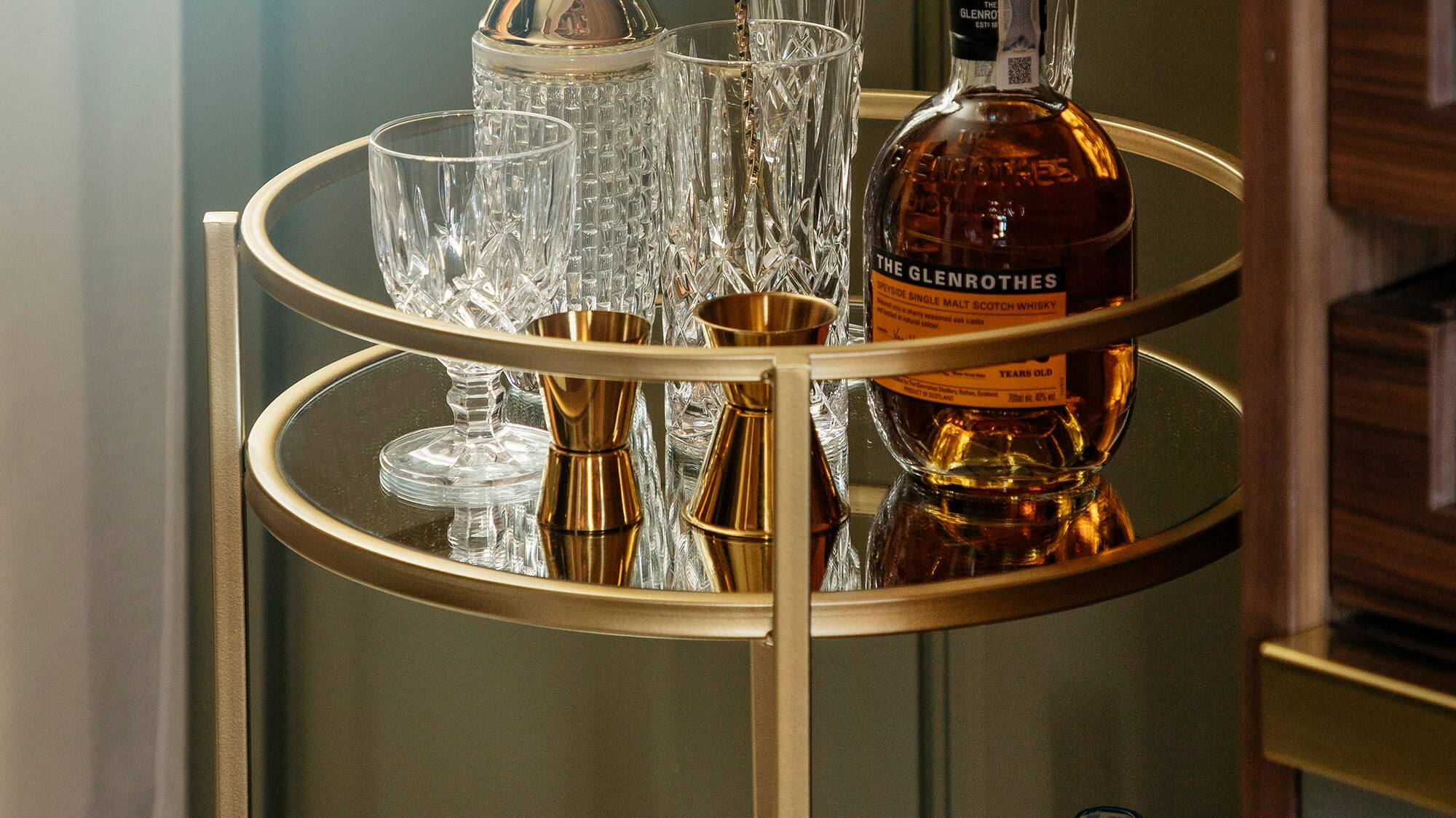 a bar cart with bottles and glasses
