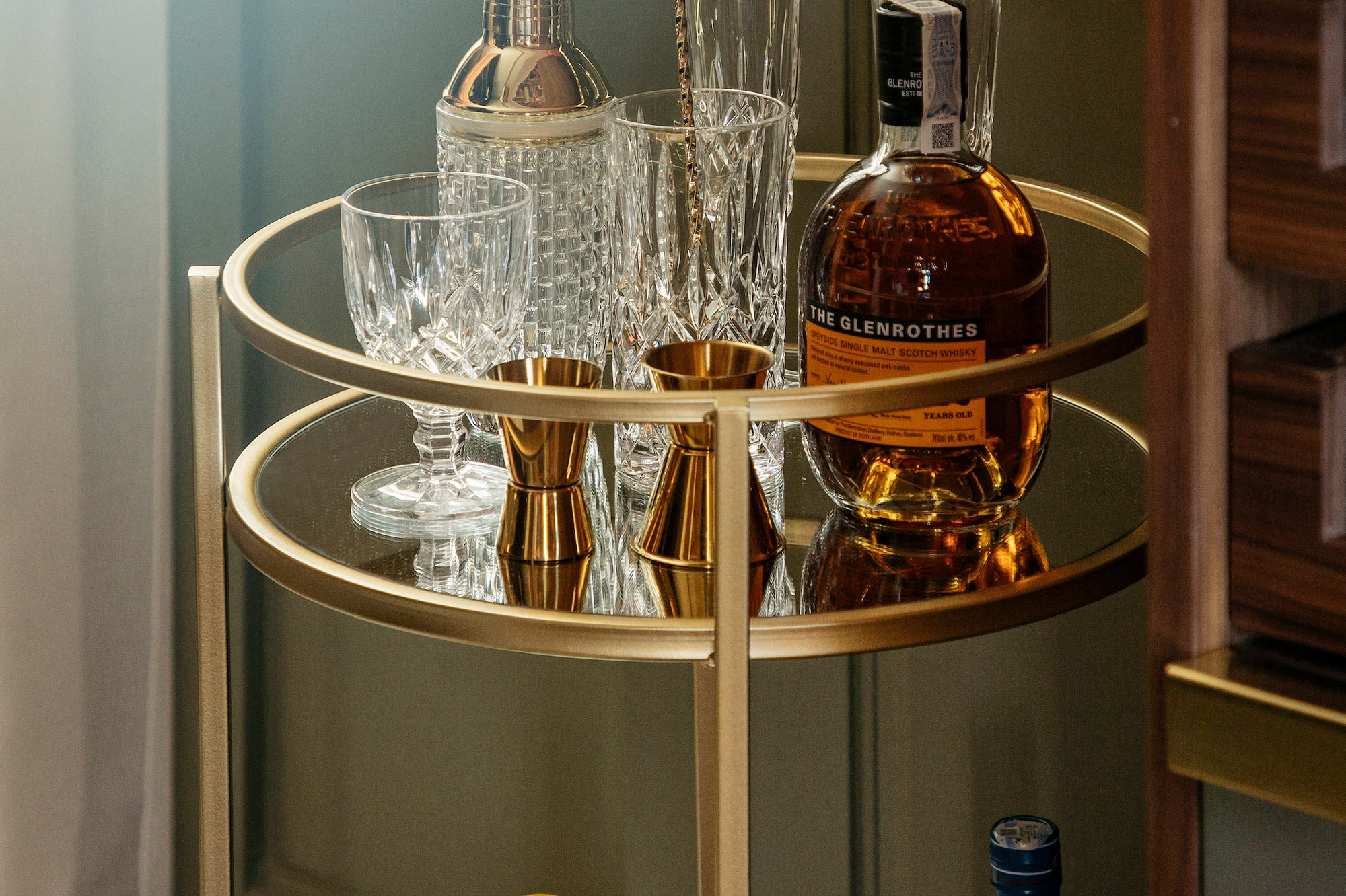 a bar cart with bottles and glasses