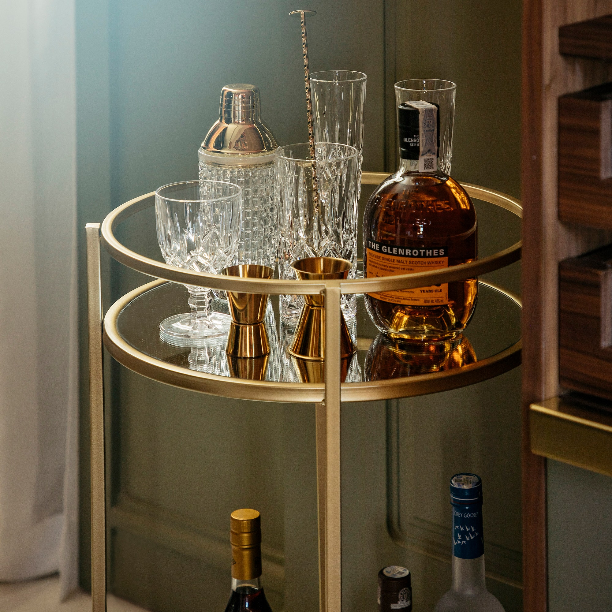 a bar cart with bottles and glasses