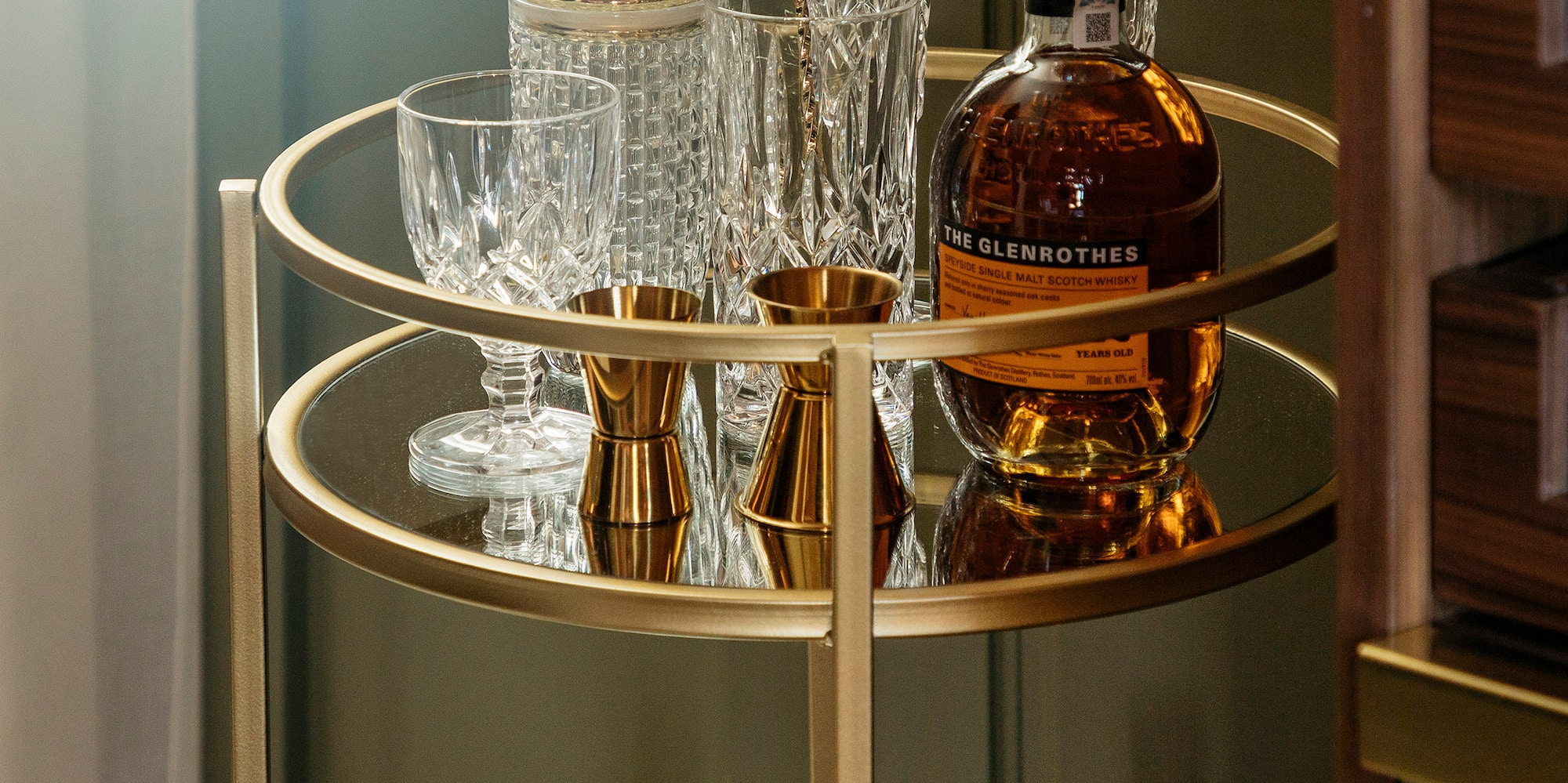 a bar cart with bottles and glasses