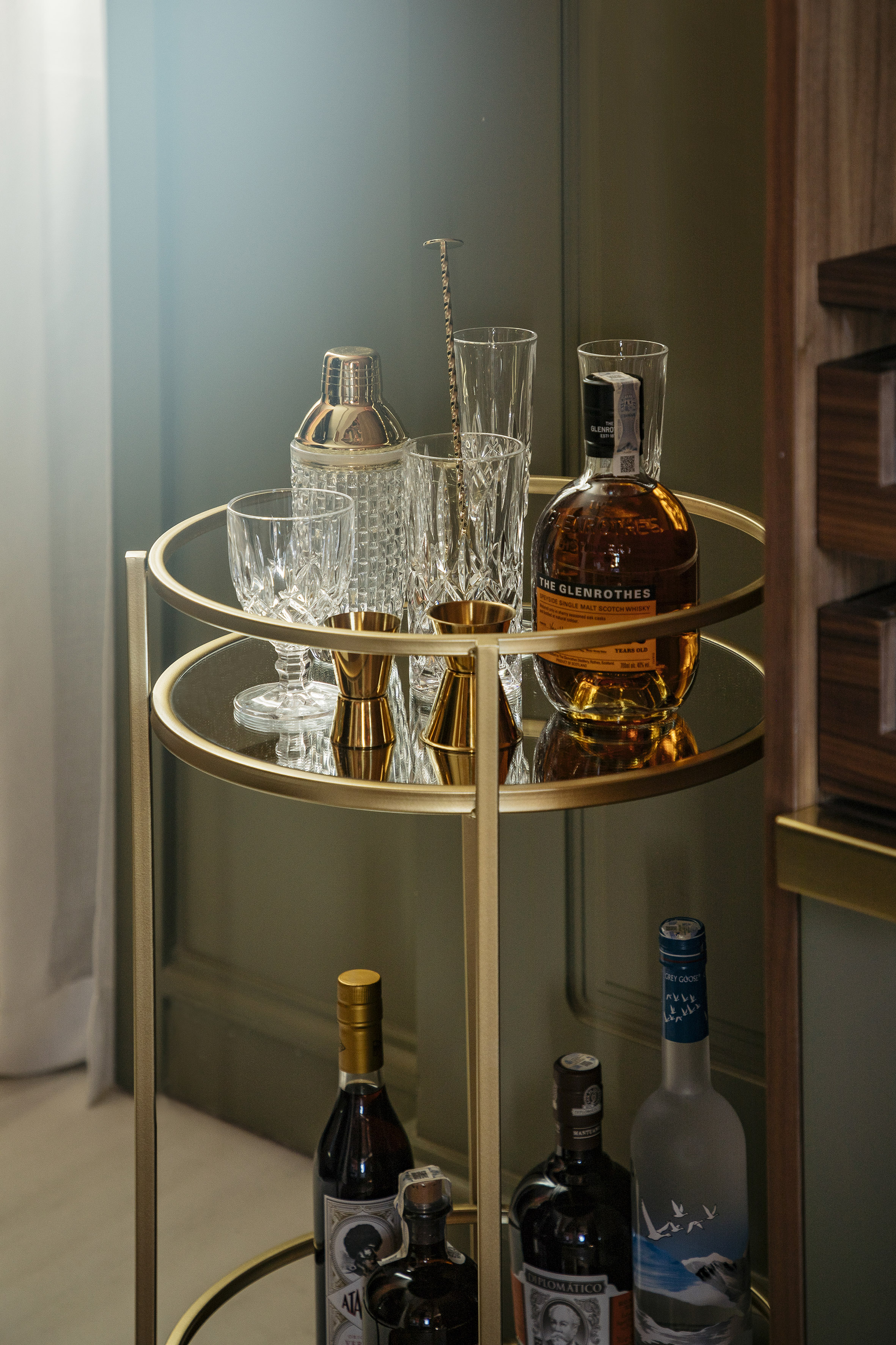 a bar cart with bottles and glasses