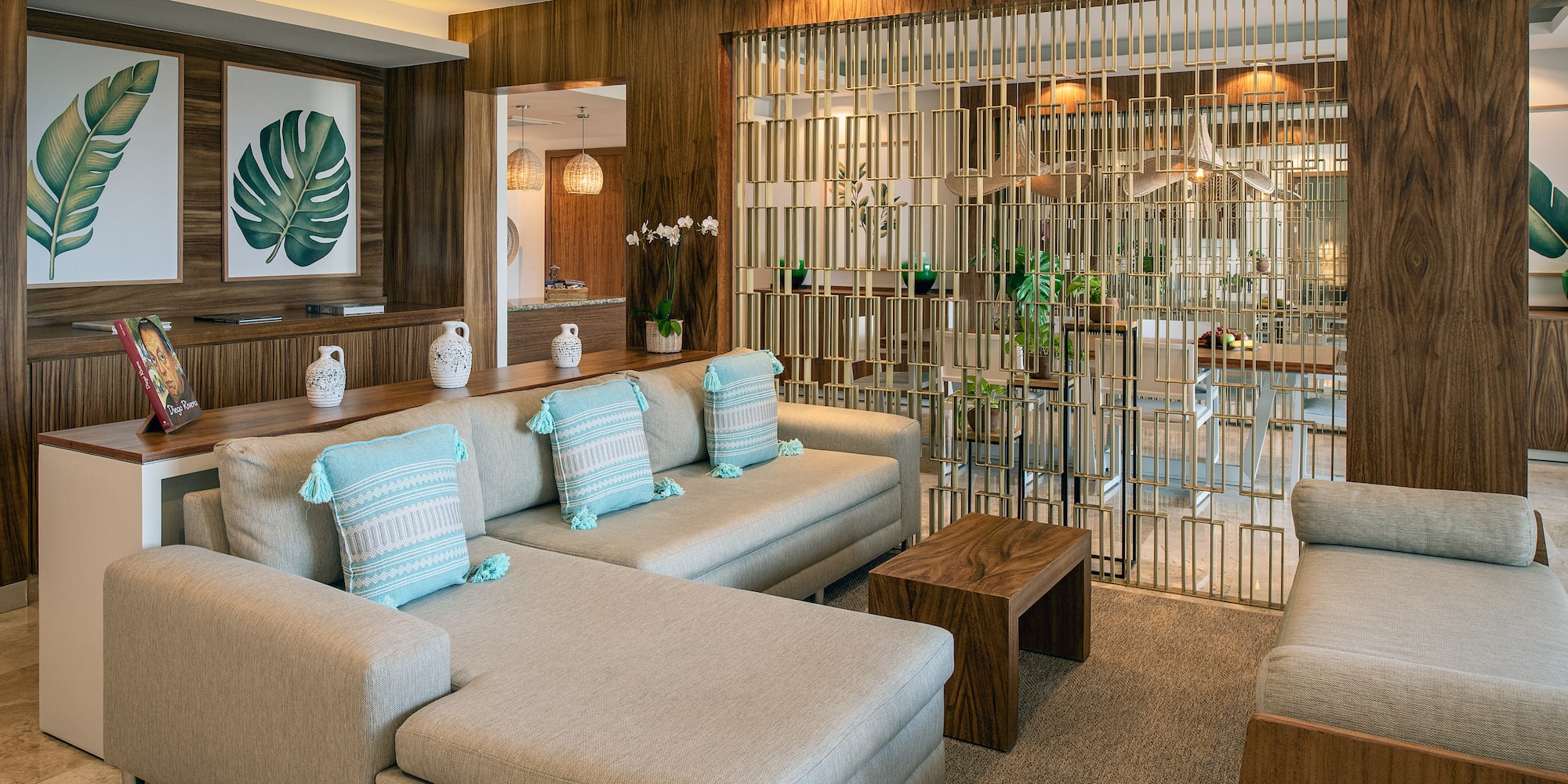 a living room with a large couch and a glass partition