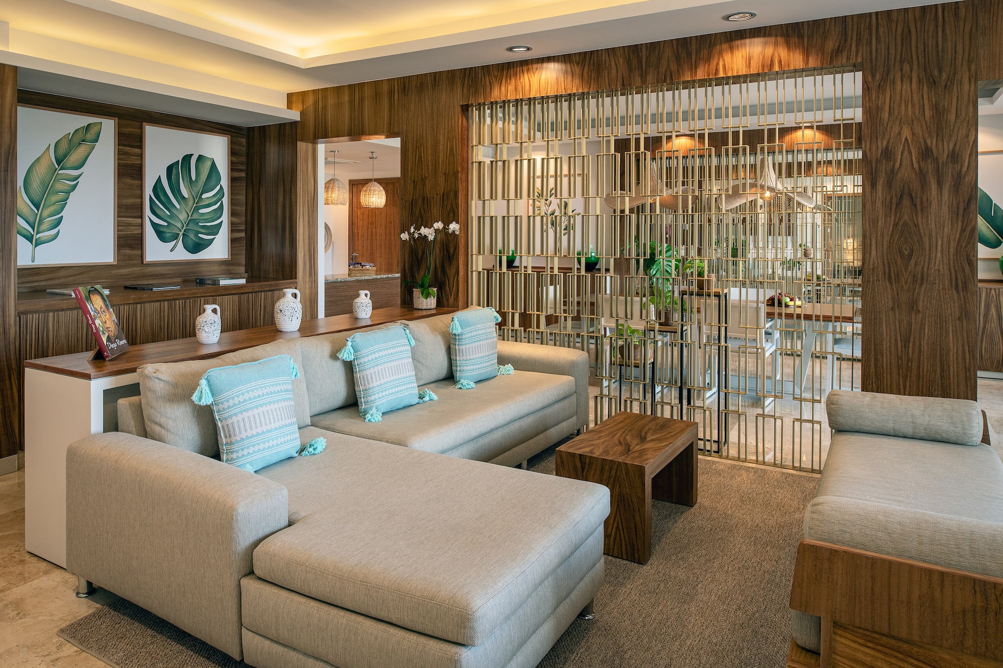 a living room with a large couch and a glass partition