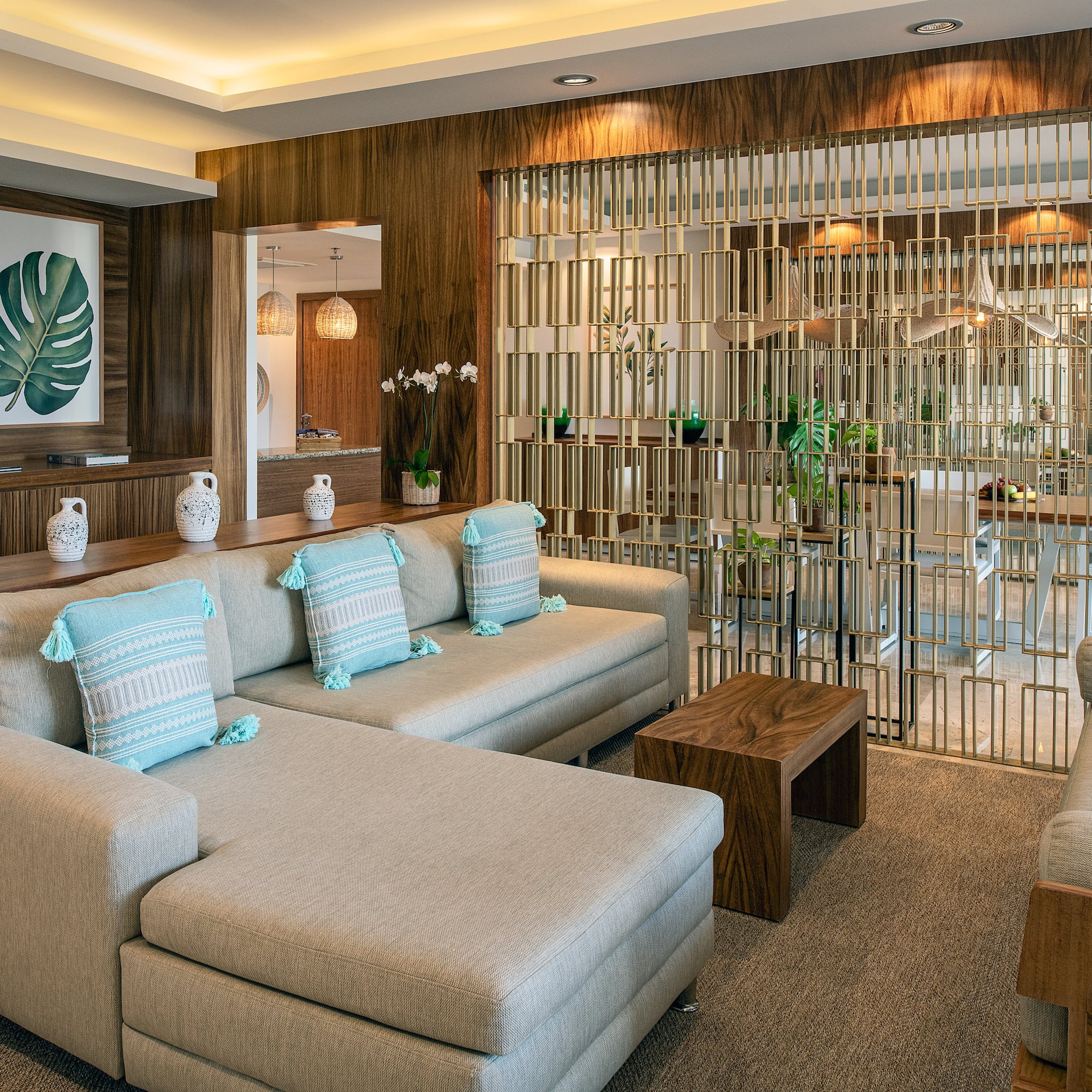 a living room with a large couch and a glass partition