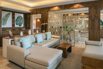 a living room with a large couch and a glass partition