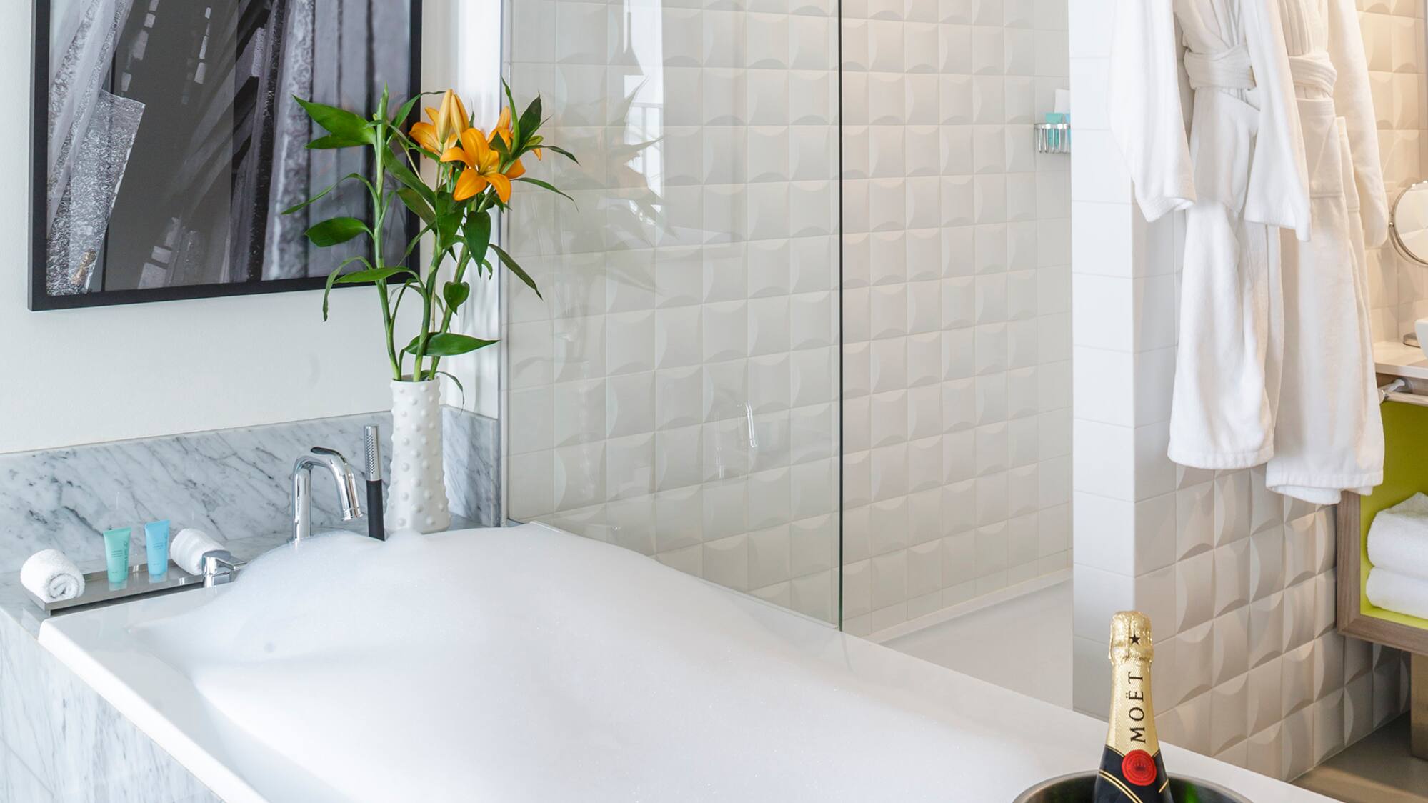 a bathtub with champagne in it and a glass shower door
