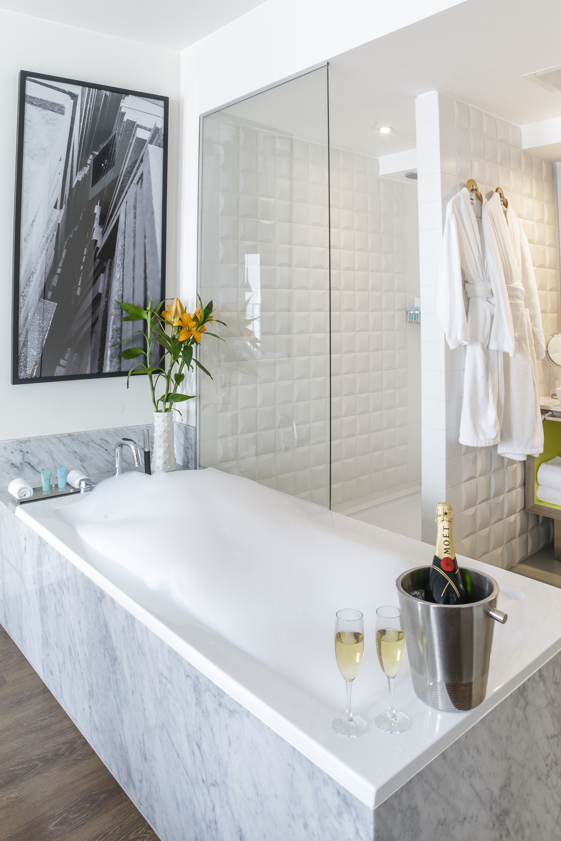 Luxury bathroom with bubbly bath, champagne, and bathrobes.