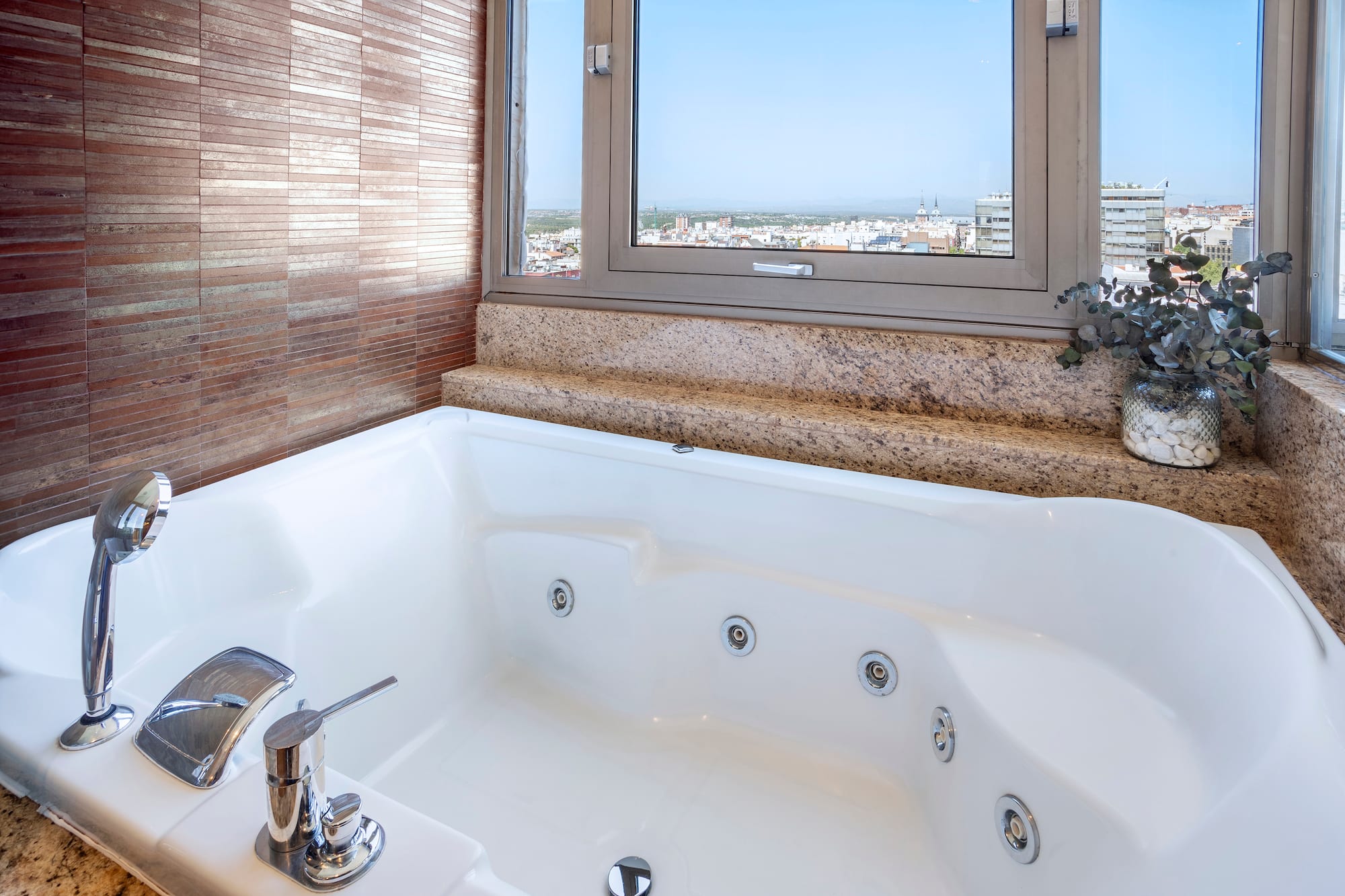 a bathtub with a window and a view of the city
