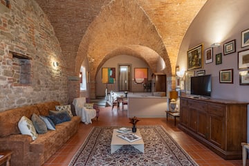 a living room with brick walls and a tv