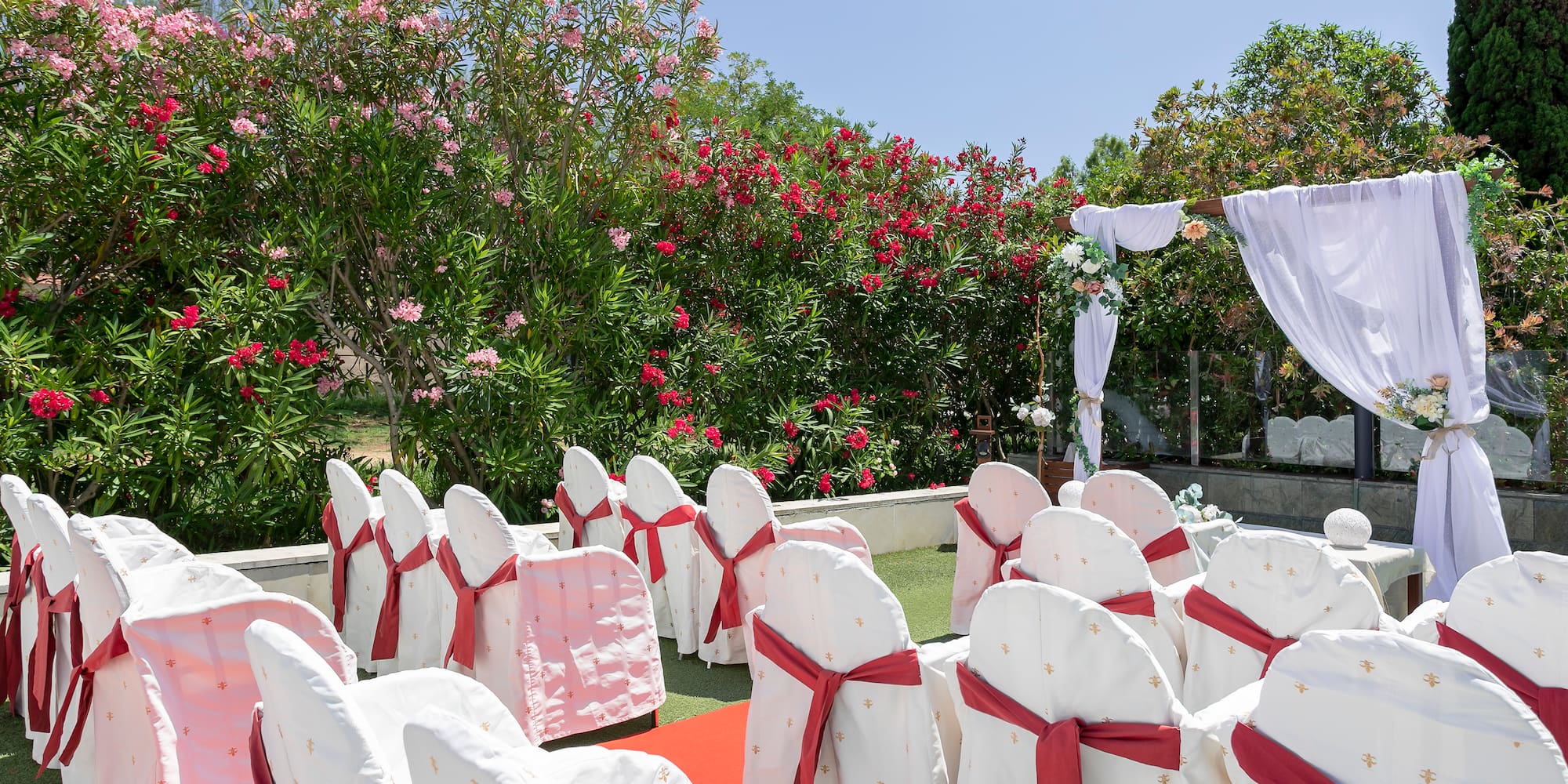 chairs and chairs with red sashes and white cloths in a garden