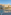 Large hotel resort with a round swimming pool, sun loungers, and palm trees.