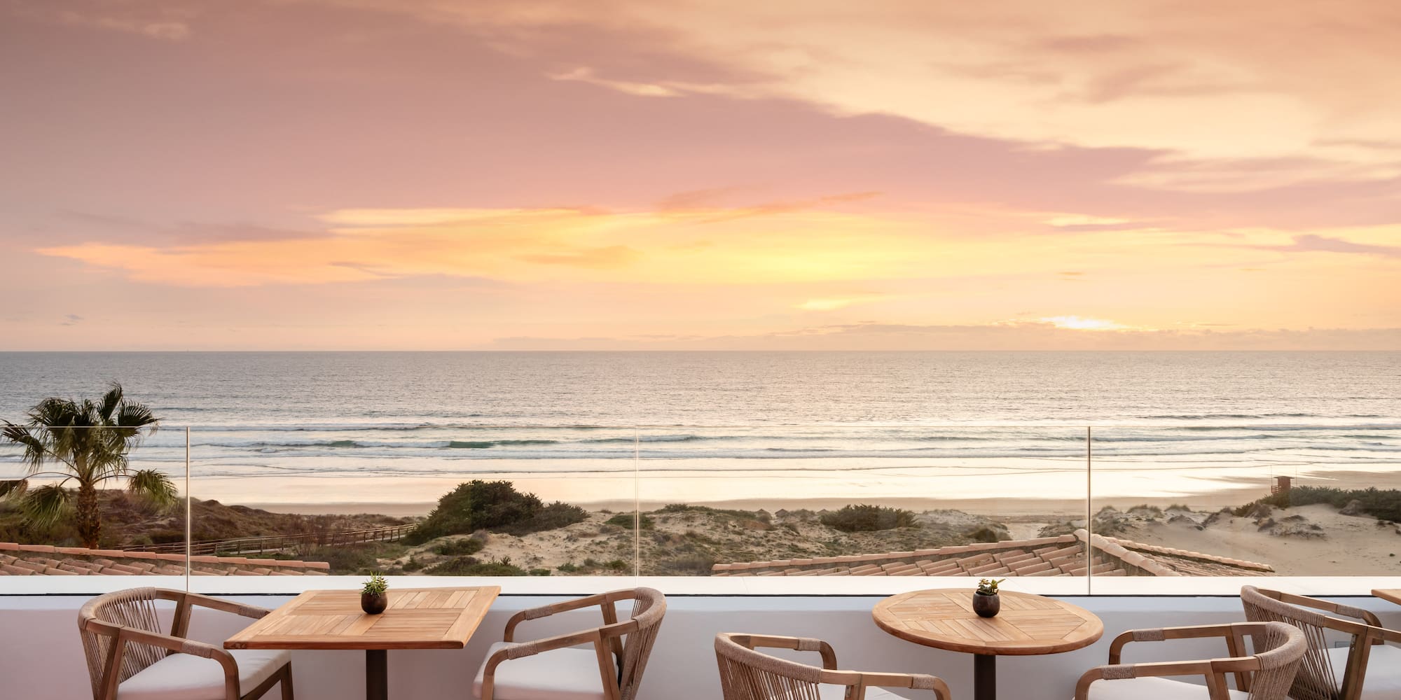 a table and chairs on a patio overlooking a beach