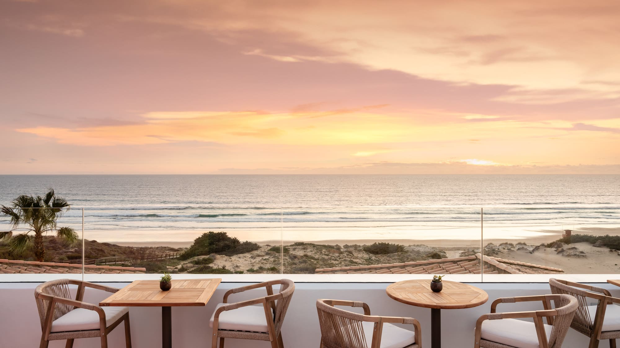 a table and chairs on a patio overlooking a beach